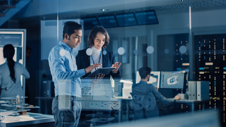 Image shows men and women in a high-tech environment studying an array of instruments